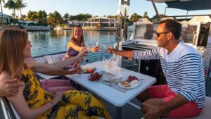 Friends toasting at the table on a powerboat on the docks