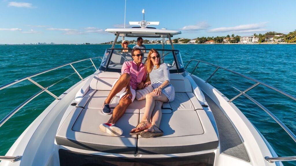 Couple lounging on the bow of a jeanneau leader 10. 5