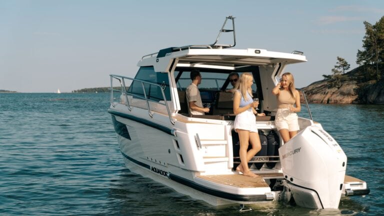 Four people onboard a stationary Aquador 250 HT.